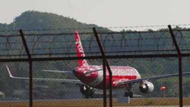 PHUKET, THAILAND - FEBRUARY 10, 2023: Passenger aircraft Airbus A320, HS-BBW AirAsia accelerating for takeoff at Phuket airport, rear view. Tourism travel concept