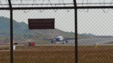 PHUKET, THAILAND - FEBRUARY 10, 2023: Boeing 737 of NOK Air taxiing to the runway, side view close-up. Background, Boeing 757 of Azur Air deceleration after landing, flaps up. Phuket Airport traffic