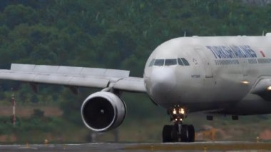 PHUKET, THAILAND - 24 Ocak 2023: Phuket Havaalanı 'na indikten sonra fren yapan Türk Hava Yolları' nın sivil uçağı. Yolcu uçuşu, çitten geçen havaalanı. Flaplar yukarı, yavaşla. Turizm seyahati kavramı