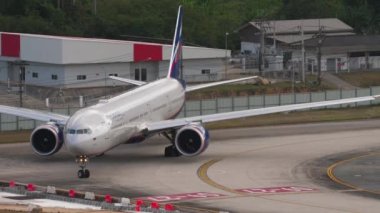 PHUKET, THAILAND - 11 Şubat 2023: Yolcu uçağı Boeing 777-300ER, RA-73141 Aeroflot, Phuket havaalanına indikten sonra terminale iniyor, ön görüş. Turizm ve seyahat kavramı