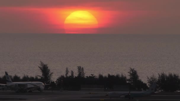 プーケット島 2023年2月11日 タクシー バックライトの飛行機 着陸後のターミナルへのタクシーのボーイング737 海と赤の日没の背景 観光と旅行のコンセプト — ストック動画