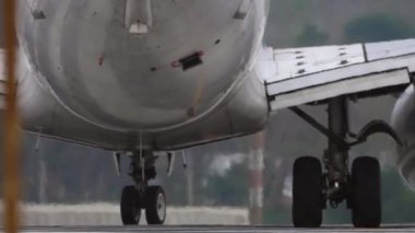 Taksideki bir uçak. Uçak motoru ve iniş takımları, havaalanı çitleri. Uçak havaalanında taksicilik yapıyor, yaklaşın..