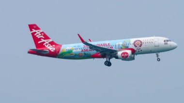 PHUKET, THAILAND - 28 HAZİRAN 2023: Airbus A320 AirAsia Sürdürülebilir ASEAN Turizm Livery Phuket havaalanına inmeden önce yaklaşıyor. Uçak uçuşları, mavi gökyüzü arkaplanı