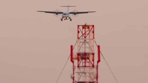 着陸に近づいてターボプロップ機の長いショット 飛行機の降下 日没または夜明け 航空機のフライ フロントビュー 観光と旅行のコンセプト — ストック動画