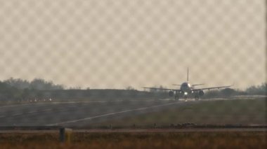 Uçak kalkış için hız ayarladı, arka ışık, ön görüş. Havaalanı çitlerinden bak.