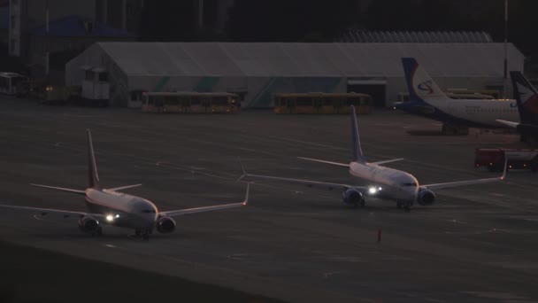 Sochi Russia 2022年7月28日 日落时分 罗西亚波音737在索契机场滑行 一排排的飞机和停机坪巴士 黎明时分 日落时分 旅游和旅行概念 — 图库视频影像
