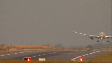 Günbatımında sıcak bir günde modern bir uçak havaalanına indi. Yolcu uçağı iniş ve fren, flaplar yukarı. Turizm ve seyahat kavramı