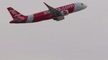 PHUKET, THAILAND - Şubat 06, 2023: Airbus A320 AirAsia 'nın ticari uçağı Phuket havaalanından havalanıyor, yan görüş. Jet uçağı kalkıyor, tırman. Turizm ve seyahat kavramı