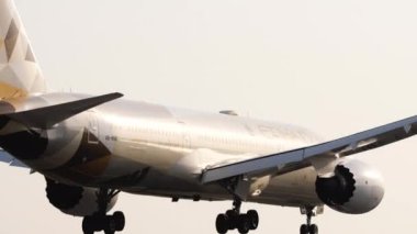 PHUKET, THAILAND - 24 Şubat 2023: Etihad Havayollarının Boeing 787 Dreamliner 'ı Phuket havaalanına indi. Yolcu uçağı geliyor. Uçağın el ele tutuşup fren yaptığı orta kare.