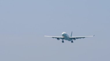 PHUKET, THAILAND - 24 Şubat 2023: Airbus A330-343, Cathay Pacific 'ten B-LAP inişe yaklaşıyor, uzun menzilli ön görüş. Uçak mavi gökyüzünde uçuyor. Turizm ve seyahat kavramı