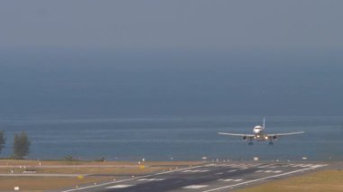 PHUKET, THAILAND - 23 Şubat 2023: Airbus A320-232, HS-PGW Bangkok Havayolları Samui Havaalanı iniş pistine iniyor. Uçak fren yapıyor, geliyor.