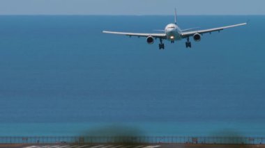 PHUKET, THAILAND - ŞUBAT 07, 2023: Phuket Havaalanına inen Cathay Pacific Airbus A330. Uçak geliyor, ön manzara. Havaalanı, deniz arka planı