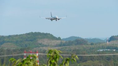 PHUKET, THAILAND - ŞUBAT 08, 2023: Singapur Havayolları 'ndan Boeing 737 Phuket havaalanına indi. Uçak sineklerinin alçalma görüntüleri. Turizm seyahati kavramı