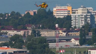 SOCHI, RUSSIA - JULY 31, 2022: Yellow helicopter flying in the blue sky, slow motion. Mil Mi-8 of Art Avia flies at Sochi airport.