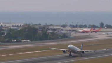 PHUKET, THAILAND - 13 Şubat 2023: Airbus A330, Phuket Havaalanı B-LAL kalkış, yan görüş. Yolcu uçağı kalkıyor ve tırmanıyor. Turizm ve seyahat kavramı