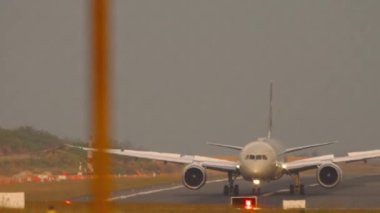 Yolcu uçağı havaalanı çitlerinden ön tarafa geliyor. Flapları aç, fren yap. Hava trafiği, havaalanı. Turizm ve seyahat kavramı
