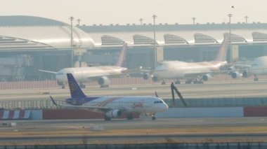 BANGKOK, THAILAND - 21 Ocak 2023: Airbus A320, Tayland 'dan HS-TXF Modern Suvarnabhumi Havaalanı, Bangkok havaalanında taksicilik yapıyor. Uçaklar terminale yanaştı. Seyahat kavramı