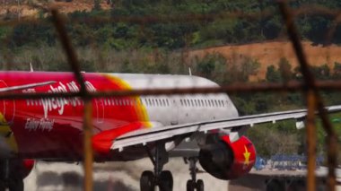 PHUKET, THAILAND - 4 Şubat 2023: Airplane Airbus A321-211, VN-A535 VietJetAir Phuket Havaalanı 'ndan kalkış. Yolcu uçağı kalkış hızını ayarladı, çitin ötesine bakın.
