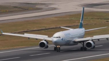 PHUKET, THAILAND - ŞUBAT 07, 2023: Phuket Havaalanı 'na indikten sonra Cathay Pacific Airbus A330 fren yapıyor. Pistteki uçak görüntüsü, yan görüş. Beneklenme