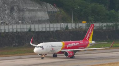 PHUKET, THAILAND - 13 Şubat 2023: Yolcu uçağı Airbus A320 VietJet Air Amazing Thailand Livery taksiing at Phuket Airport. Havaalanındaki uçak. Turizm ve seyahat kavramı