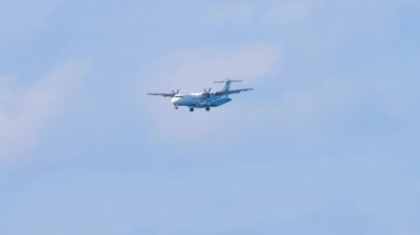 PHUKET, THAILAND - 4 Şubat 2023: Bangkok Air turboprop uçağı iniş yapmadan önce yaklaşıyor, uzak çekim. Bir uçağın yan görüntüsü. Turizm ve seyahat kavramı