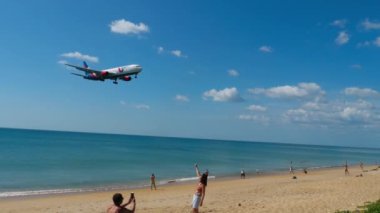 PHUKET, THAILAND - Şubat 05, 2023: Yavaş çekim, Azur Air 'in Boeing 767' si Phuket Havalimanı 'na iniş yapıyor. Turistler uçağın fotoğraf ve selfie 'sini çekmek için gelirler.