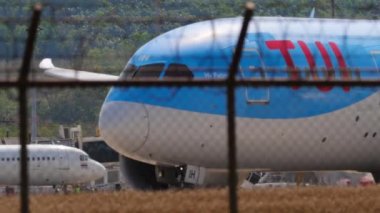 PHUKET, THAILAND - 15 Şubat 2023: Bir Boeing 787-8 Dreamliner 'ın yakın çekimi, TUI' den G-TUIH Phuket Havaalanı 'ndaki piste iniyor. Çitin üzerinden geçen uçak. Havaalanı. Turizm ve seyahat kavramı