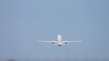 Rear view of a jet passenger plane take off, departure. Runway, airfield, airport. Unrecognizable airliner flies away. View through the airport fence