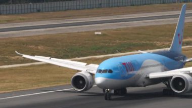 PHUKET, THAILAND - 13 Şubat 2023: Phuket havaalanına indikten sonra inen Boeing 787 Dreamliner TUI uçağının orta çekimi. Turizm ve seyahat kavramı