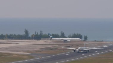 PHUKET, THAILAND - 13 Şubat 2023: Katar Havayolları 'nın Airbus A330' u Phuket havaalanına iniş ve frenleme. Denizin arka planı. Turizm ve seyahat kavramı