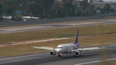 PHUKET, THAILAND - 13 Şubat 2023: Airplane Airbus A320, Tayland gülüşlü HS-TXM Phuket havaalanına geliyor, yan görüş. Kanatçıklar yukarı, hız aşağı