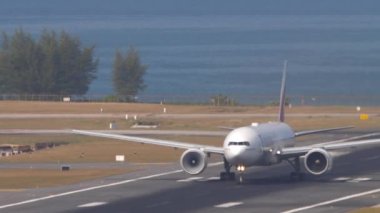 PHUKET, THAILAND - 23 Şubat 2023: Boeing 777 Emirates Phuket havaalanından havalanıyor. Geniş gövdeli uçak kalkışı. Turizm seyahati kavramı