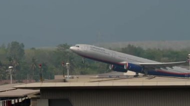 PHUKET, THAILAND - 25 Şubat 2023: Aeroflot uçağı Phuket Havaalanı, yan görüş. Yolcu jeti kalkıyor. Aicraft gökyüzüne tırmanıyor. Turizm ve seyahat kavramı