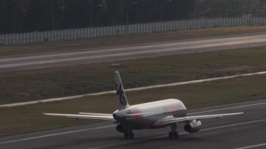PHUKET, THAILAND - 11 Şubat 2023: Jetstar 'ın Airbus A320 uçağı Phuket Havaalanı' ndan havalanmak için hızlanır. Uçak kalkıyor. Havaalanının panoramik manzarası, arka ışık. Turizm ve seyahat kavramı