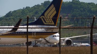 PHUKET, THAILAND - 14 Şubat 2023: Phuket Havaalanı 'nda taksicilik yapan Singapur Havayolları' ndan 9V-MGC jet uçağı Boeing 737. Uçağın taksideki görüntüsü. Turizm ve seyahat kavramı