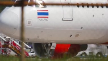 PHUKET, THAILAND - 26 Kasım 2016: Phuket havaalanında taksicilik yapan VietJet yolcu uçağı. Havaalanı çitlerinden havaalanı manzarası, bulanık. Turizm ve seyahat kavramı