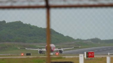 PHUKET, THAILAND - 26 Kasım 2017: AirAsia 'nın ticari uçağı Phuket havaalanına iniş ve frenleme. Kanatları açık, dikiz manzaralı bir uçak. Turizm ve seyahat kavramı