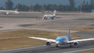 PHUKET, THAILAND - 13 Şubat 2023: Phuket havaalanına indikten sonra Boeing 787 Dreamliner TUI uçağı fren yapıyor. Uçak yolcusunun varış görüntüsü. Turizm ve seyahat kavramı