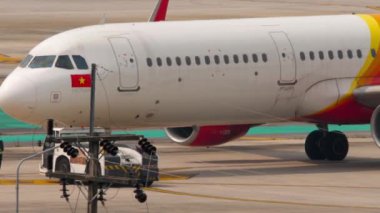 PHUKET, THAILAND - 25 Şubat 2023: traktör ve yolcu uçağı, havaalanı. Vietnam JetAir 'in Jet uçağı Phuket Havaalanı' ndaki terminalden kalkıyor. Uçak havalanmaya hazır. Turizm ve seyahat kavramı