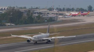 PHUKET, THAILAND - 13 Şubat 2023: Katar Havayolları 'nın Airbus' u Phuket Havaalanı 'na iniş ve frenleme. Yolcu uçağı pistte. Turizm ve seyahat kavramı