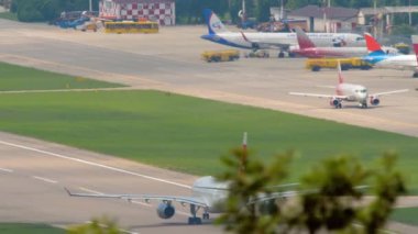 SOCHI, RUSSIA - 01 AĞOS 2022: Yolcu uçağı A330-243, Nordwind Havayolları 'nın RA-73270 sefer sayılı uçağı Sochi havaalanından kalkıyor. Arka planda satır düzlemleri