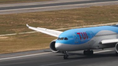 PHUKET, THAILAND - 13 Şubat 2023: Yolcu taşıyıcısı Boeing 787 TUI Dreamliner Phuket havaalanında taksicilik yapıyor. Uçak dönüyor, yan görüş. Dışarıdaki kokpite yakın çekim.