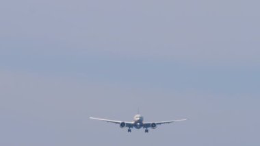 İniş için tanımlanamayan bir üniforması olan yolcu uçağının ön görüntüsü.