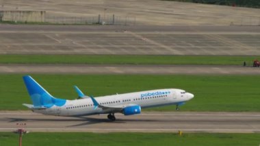 SOCHI, RUSSIA - 02 AĞUSTOS 2022: Boeing 737, RA-73305 Pobeda ivme ve kalkış, Sochi havaalanına tırman, yan görüş. Turizm ve seyahat kavramı