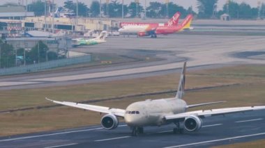 PHUKET, THAILAND - Şubat 03, 2023: Etihad Havayolları 'nın Boeing 787 Dreamliner' ı, Phuket havaalanında fren yapıyor. Uçak pistinde yolcu uçağı. Kanatçıklar yukarı, hız aşağı.