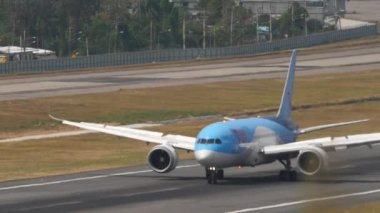 PHUKET, THAILAND - 13 Şubat 2023: Boeing 787 Dreamliner TUI Phuket havaalanına indikten sonra fren yapıyor. Uçak yolcusunun varış görüntüsü. Turizm ve seyahat kavramı