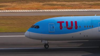 PHUKET, THAILAND - 19 Şubat 2023: Yolcu uçağı Boeing 787 TUI Fly, Phuket Havaalanında taksicilik yapıyor. Taksiyoldaki uçağın sinematik görüntüsü. Turizm ve seyahat kavramı