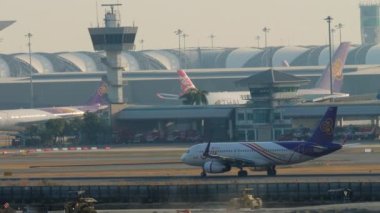 BANGKOK, THAILAND - 21 HAZİRAN 2023: Ticari uçak Airbus A320 of Thai Smile Havaalanında taksicilik. Uçaklar terminale yanaştı. Modern bir havaalanının havaalanı manzarası