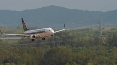 PHUKET, THAILAND - 19 Şubat 2023: Phuket Havaalanına inen Singapur Havayolları 'ndan Boeing 737, 9V-MGK. Bir uçağın gelişinin sinematik görüntüleri. Turizm ve seyahat kavramı