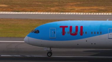 PHUKET, THAILAND - 19 Şubat 2023: Phuket Havaalanında TUI Fly 'ın Boeing 787 Dreamliner' ı. Taksiyoldaki uçağın sinematik görüntüsü. Uçak kokpitinin yan görüntüsü, iniş takımları, pencereler.